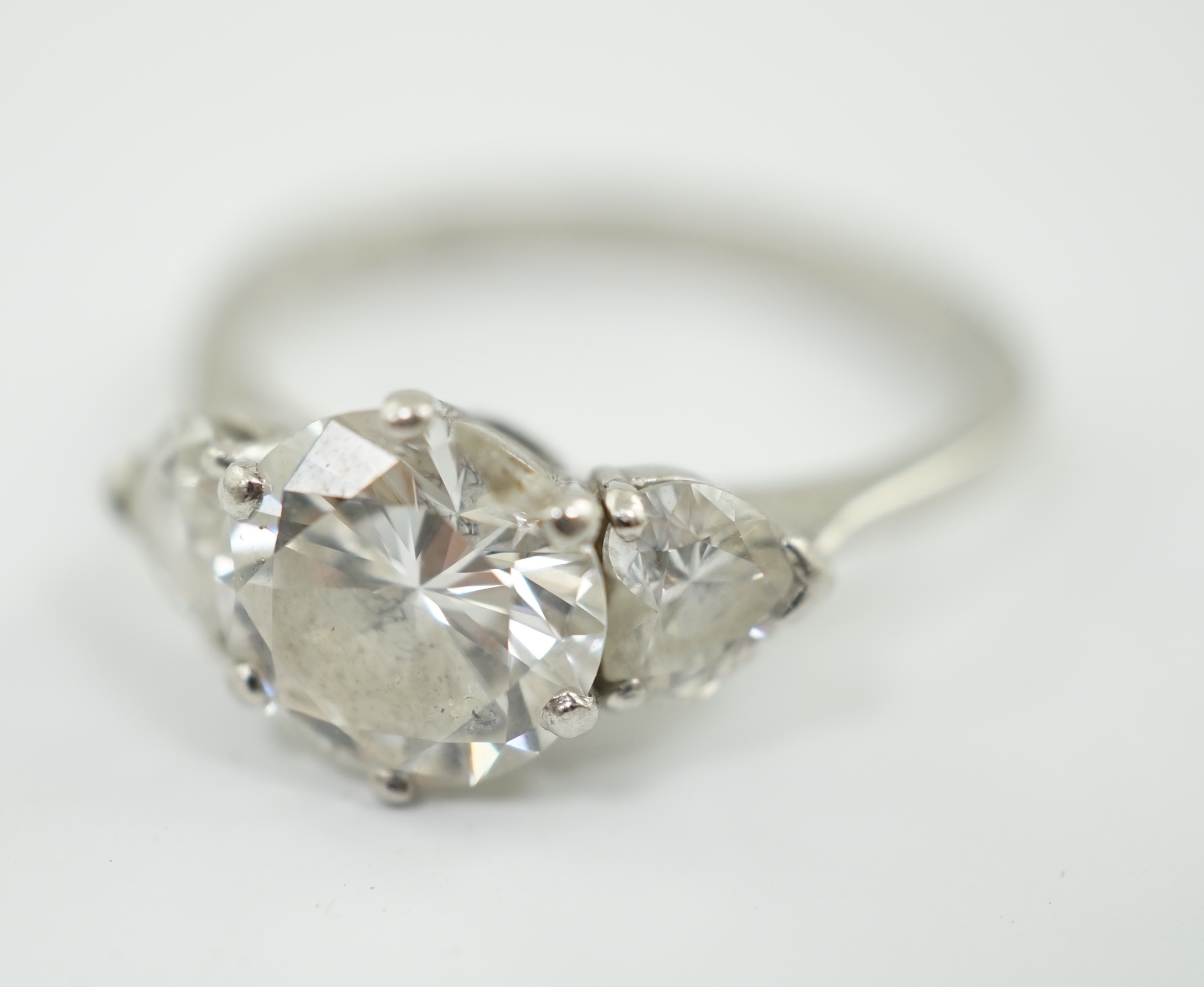 A modern Boodles & Dunthorne platinum and single stone diamond ring, with two stone heart shaped diamond set shoulders